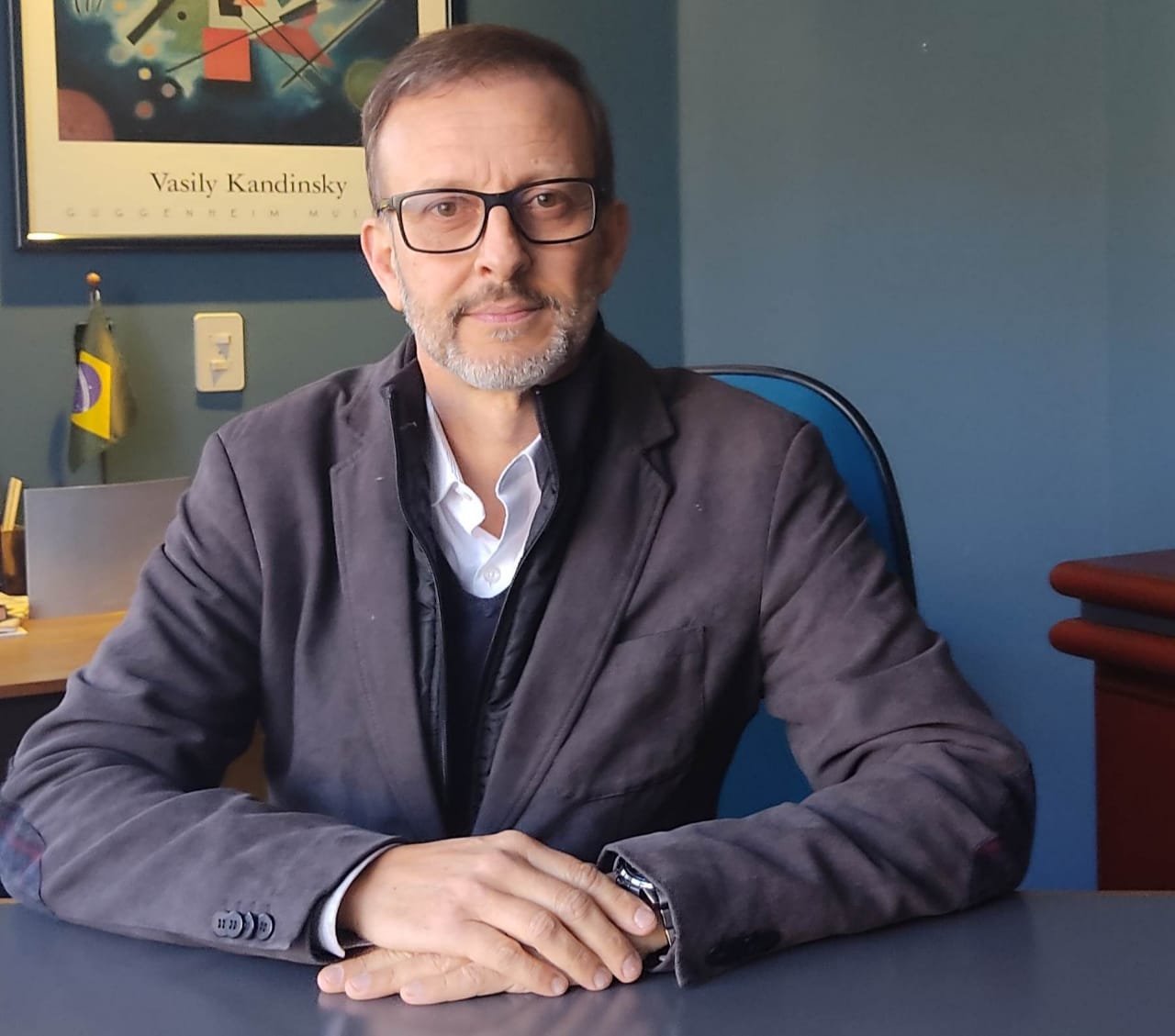 foto do presidente do Sivergs, um homem, de óculos, sentado em uma mesa